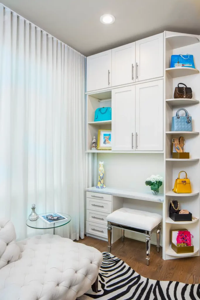 A beautiful vanity center inside a walk-in closet with seating and storage