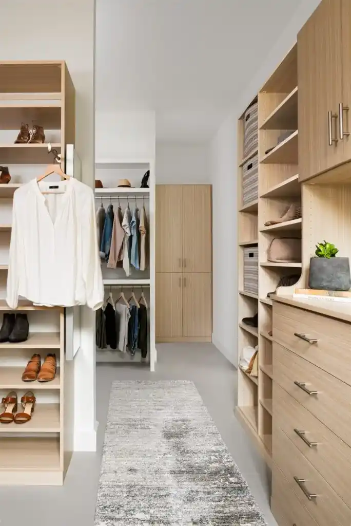 A walk-in closet with storage shelving and a hanging shirt