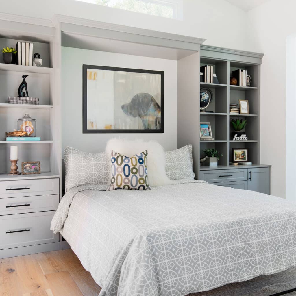 A gray shaker panel bed with shelves. Murphy beds with custom shelves allow you to display and store items effortlessly.